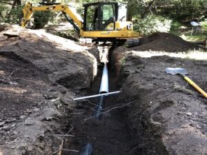 backhoe raising a septic system.