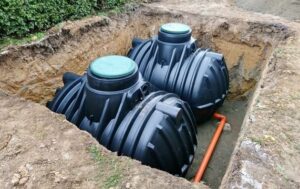 Two black septic tanks installed in the ground.