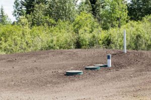 A completed and covered septic tank in the ground.