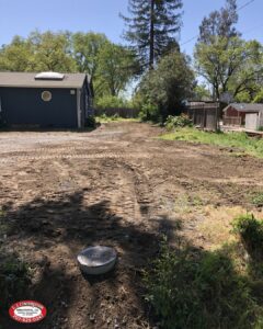 Drain field in a backyard with a building in the background