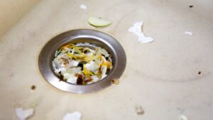 A sink drain clogged with particles of food and other waste.