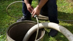 An opened septic tank being worked on by a professional.
