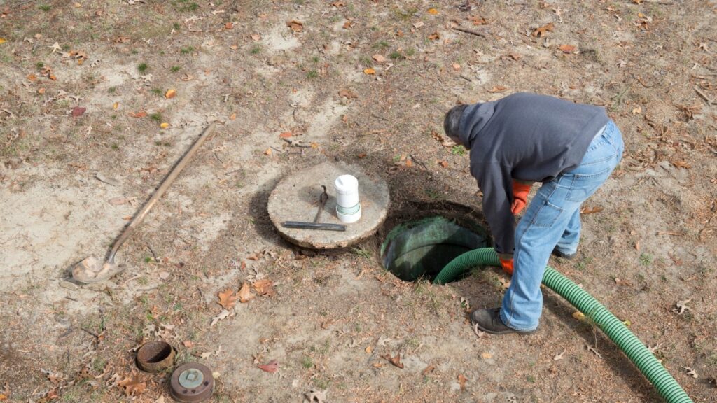 An opened septic system that is being professionally pumped.