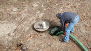 An opened septic system that is being professionally pumped.