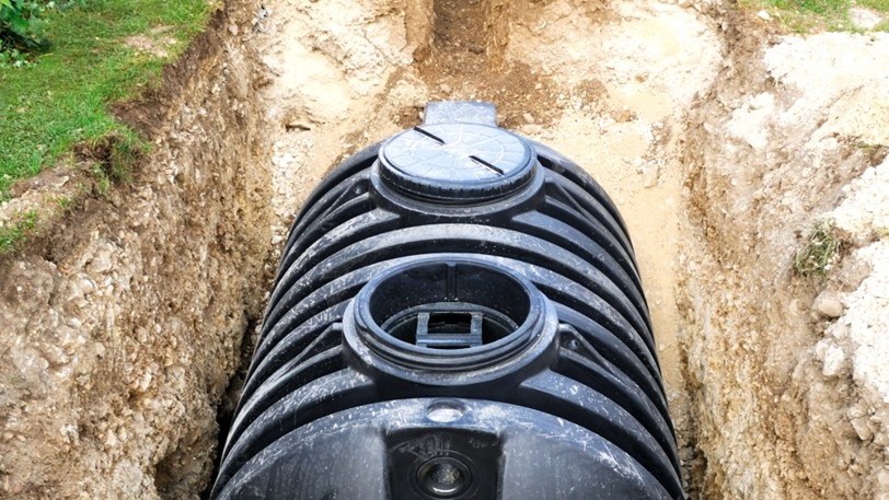 An opened drain field with a newly installed septic tank inside.