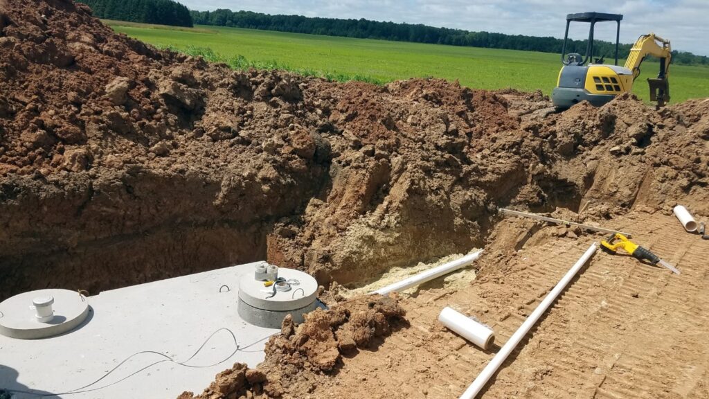 A septic tank recently installed into the ground next to piles of dirt.